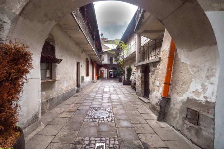 a stone building that has a sign on a sidewalk