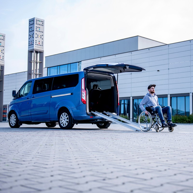 a man riding a snowboard down a snow covered road