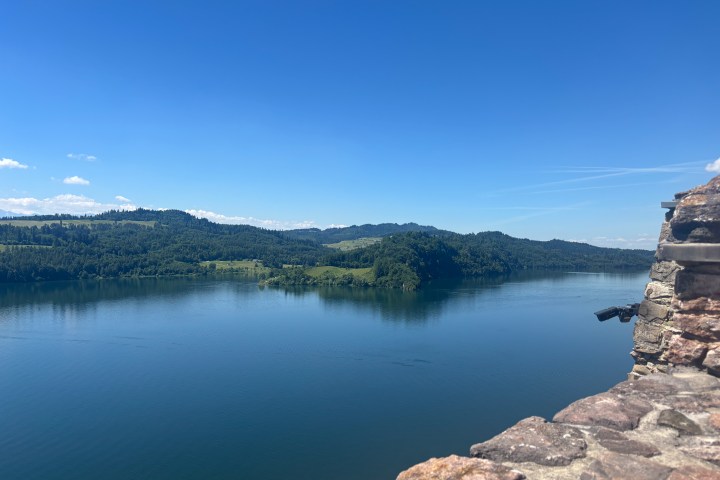Scenic view of a lake with distant hills under a clear blue sky.