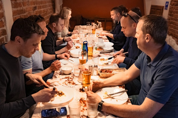People dining together at a long table in a warm, cozy setting.
