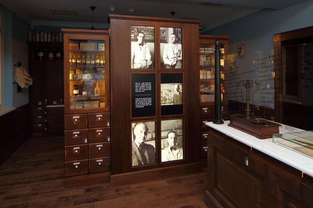 Vintage pharmacy display with photos, shelves, and drawers.