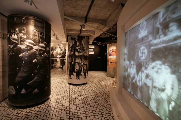Museum exhibit with historical photographs and projected WWII imagery.