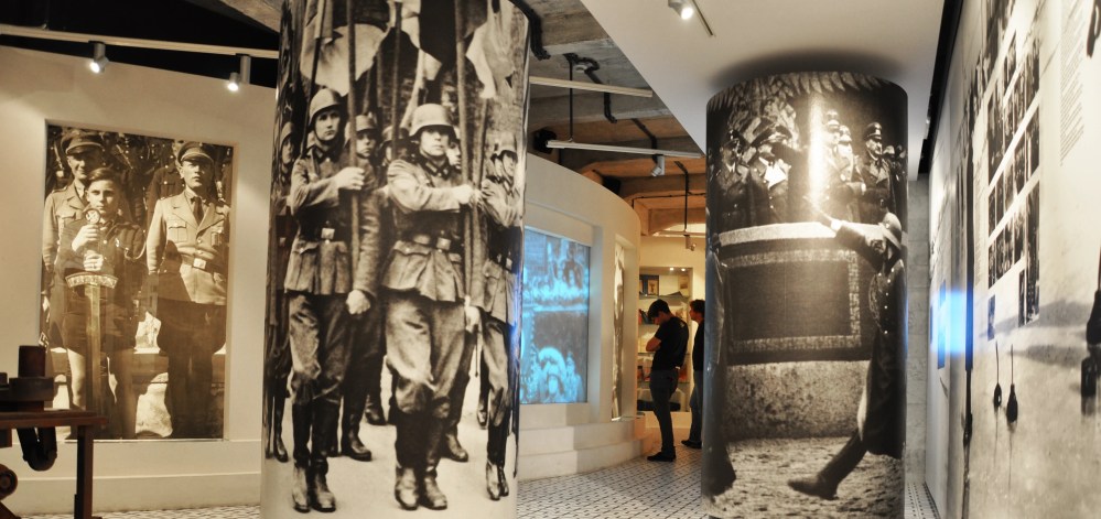 Museum display with large historical photos and modern exhibits.