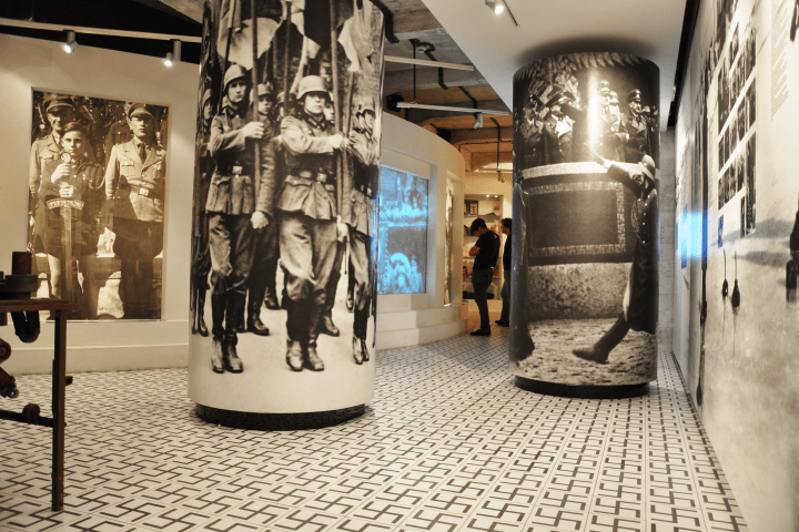 Museum display with large historical photos and modern exhibits.