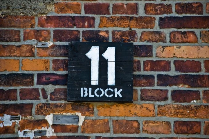 Black sign with '11 Block' in white text on a brick wall.