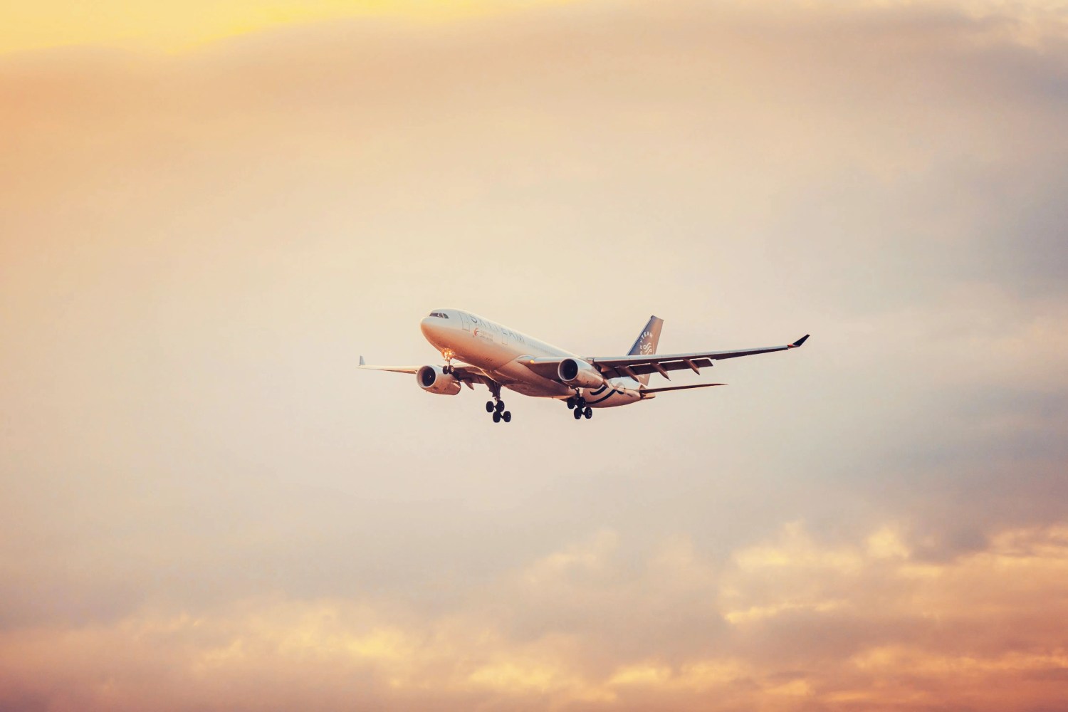 Airplane flying against a backdrop of a colorful sunset sky.