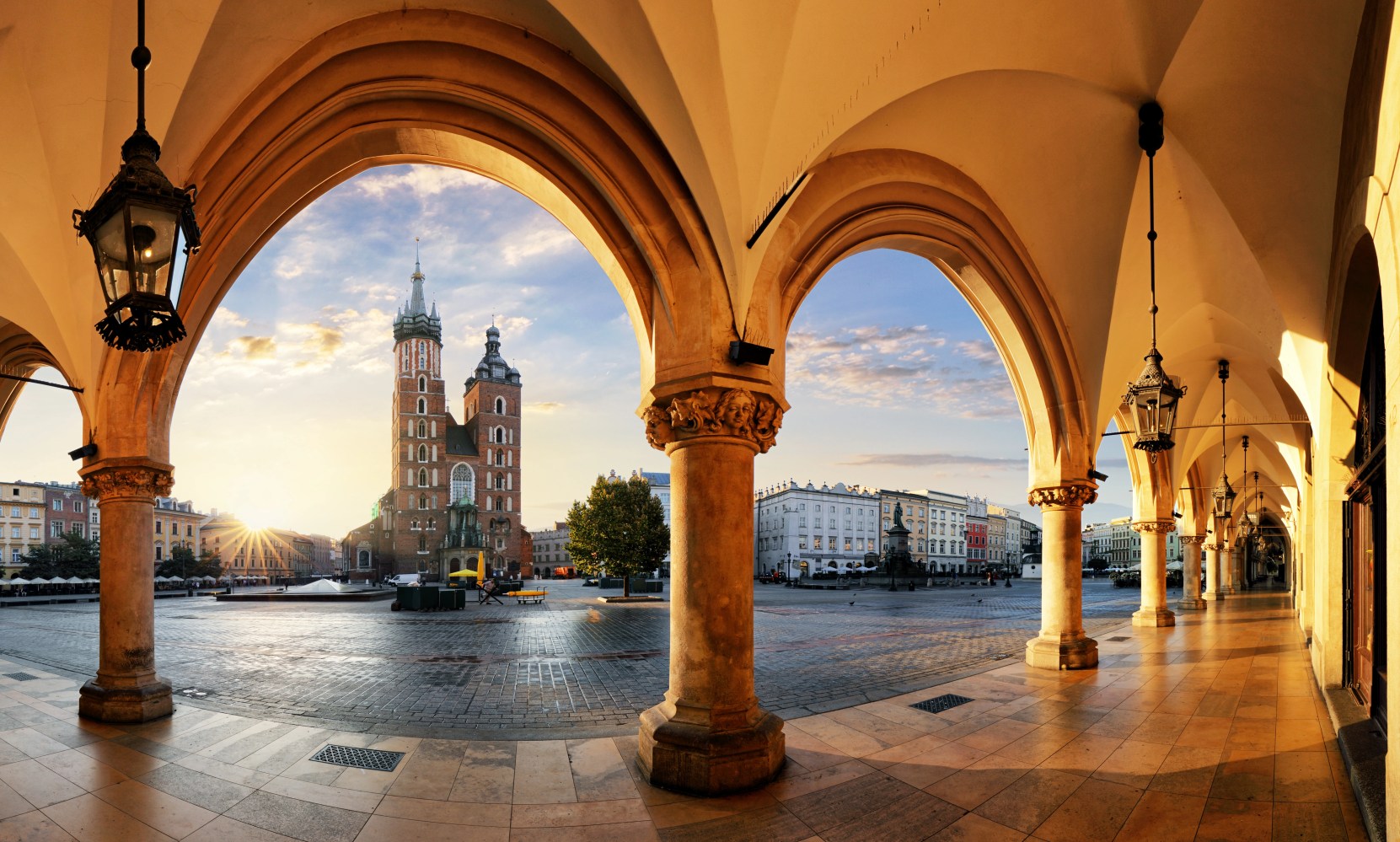 Sunset view of a cathedral through archways with historical architecture.